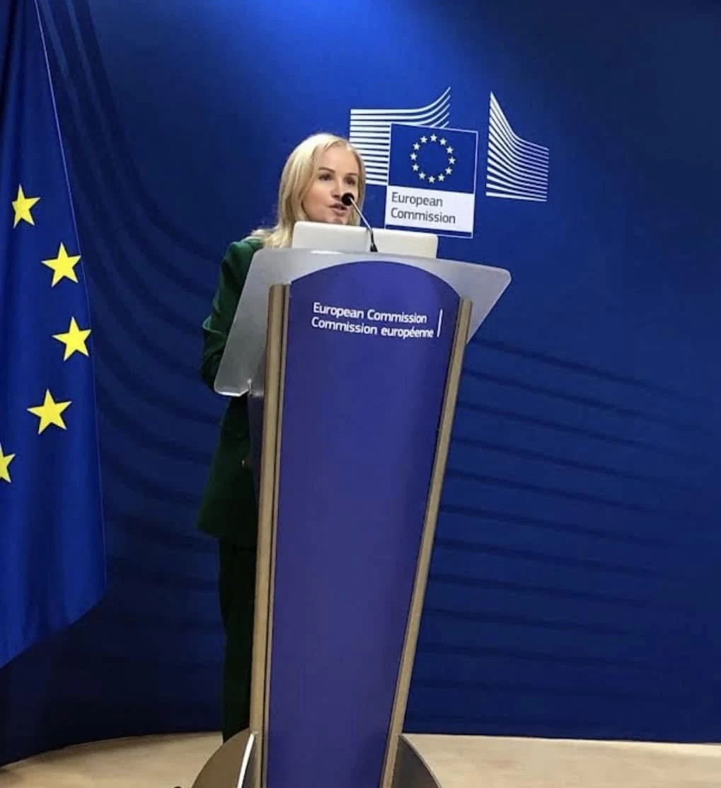 Diane Nevin speaking at a European Commission podium in Brussels